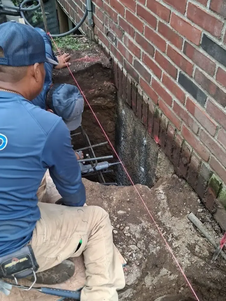 Our crew digging out along a brick foundation wall