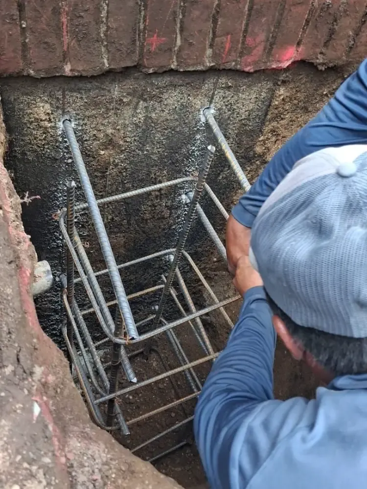 A rebar cage ready for the pour beside a foundation wall