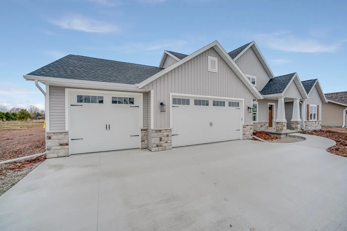 A new home with two white carriage-style garage doors
