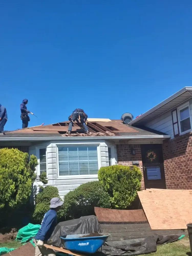 Our roofers working across a Long Island ranch house