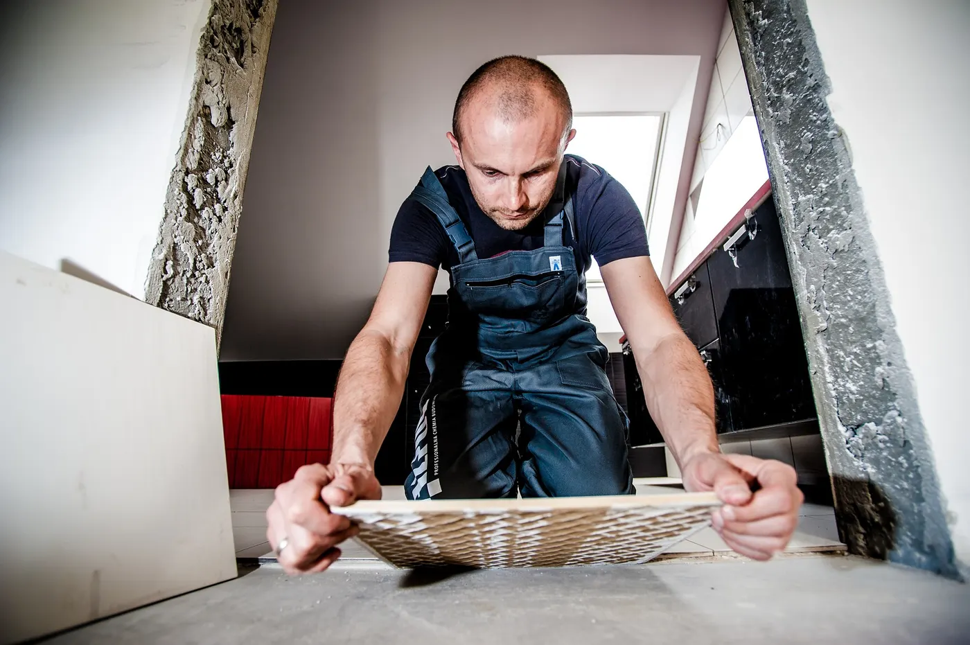 A tile installer cutting and setting tile on site